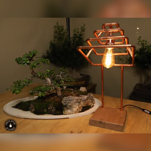 Lampe de table en forme de pyramide en cuivre sur son socle en chêne