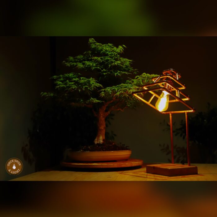 Lampe de table en forme de pyramide en cuivre sur son socle en chêne